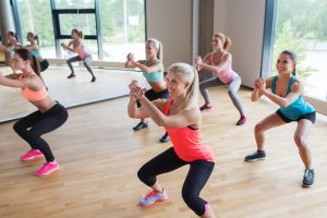 group of women making squats in gym